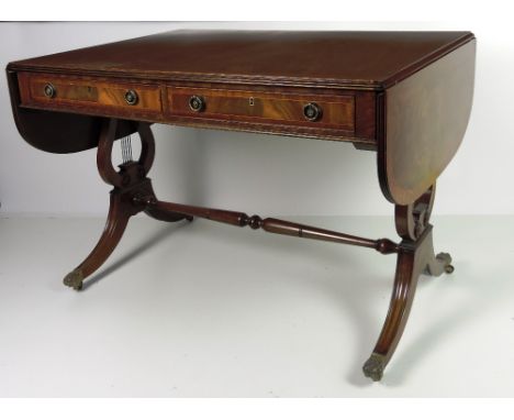 A Regency style crossbanded mahogany Sofa Table, with two oak lined frieze drawers on lyre supports and outswept feet, with b