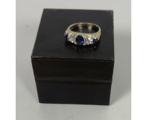 An attractive Ring, with three blue stones and one oval .85ct and two round .13ct (cumulative), and with two .35ct, 4.6mm rou