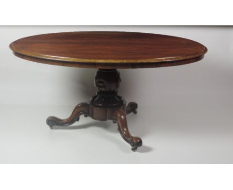 A fine Victorian period attractively figured Victorian period oval rosewood Dining Table, with moulded rim on a heavy carved 