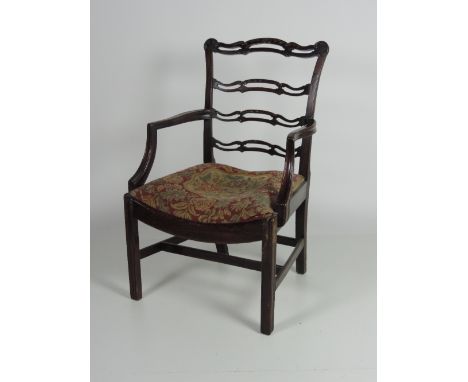 A large Chippendale style early 19th Century ladder back Armchair, with four carved and pierced rails, on curved (later) drop