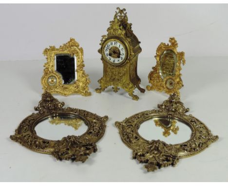 A pair of embossed cast brass circular Wall Mirrors; two similar gilt metal Table Mirrors with inset clocks, decorated with f