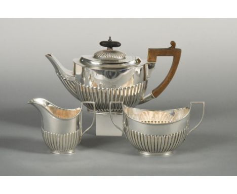 An Edward VII silver three piece tea set, by William Hutton & Sons, London 1901, the teapot of oval form with half gadrooned 