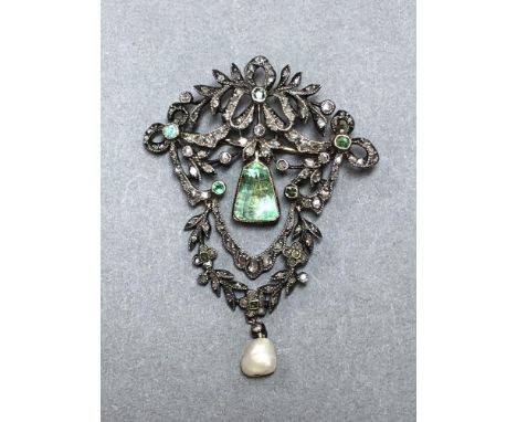 A Belle Epoque emerald, diamond and pearl pendant brooch, in the garland style with ribbons and leafy stems and with an artic