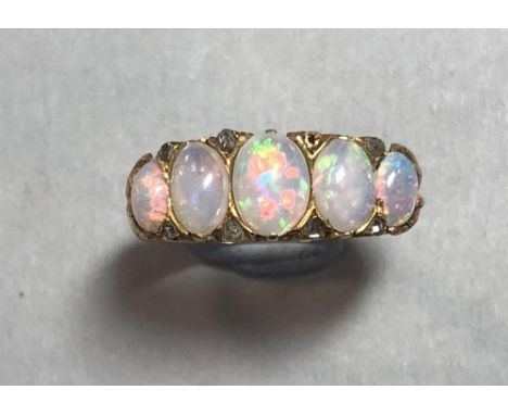 An opal and diamond ring set in 18ct gold, the five graduating oval cabochon opals separated by four pairs of diamond sparks 