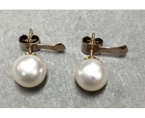 A pair of cultured South Sea pearl earstuds cased by Garrard & Co, each 10.5mm white pearl on a small petal cup and post, to 