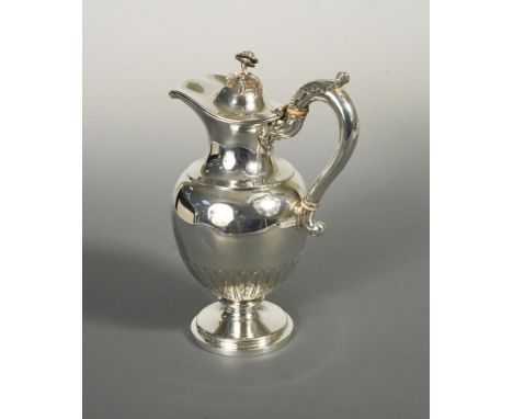 A William IV silver hot water jug by Paul Storr, London 1837, the ovoid body embossed with stiff leaf design to the base, the