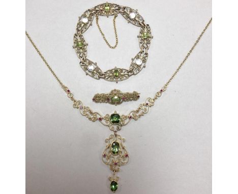 A green tourmaline and ruby filigree necklace with matched peridot and ruby brooch, and a peridot and mother-of-pearl bracele
