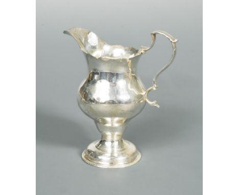 A George III silver cream jug by Hester Bateman, London 1775, pyriform below a cut edge, with flying scroll handle and raised