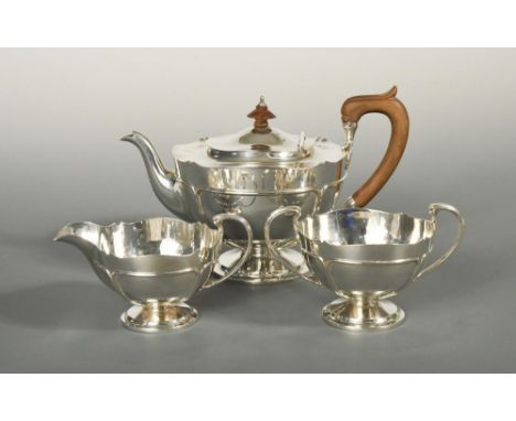 An Art Nouveau style silver three piece tea set, by Pearce & Sons, London 1920, the teapot of circular form, raised on a pede