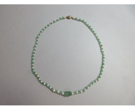 An emerald and seed pearl necklace with diamond set clasp, composed of alternating faceted emerald beads and similarly sized 