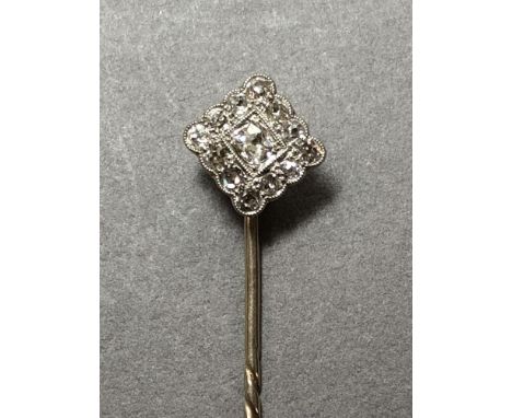 A diamond set stick pin, designed as a flat carré with a central old oval cut diamond claw set in a millegrain edged square f