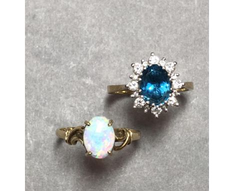 A blue topaz and diamond cluster ring together with an opal, single stone ring, the first with an oval cut saturated blue top