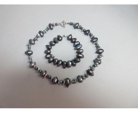 An unusual grey cultured pearl necklace with matched bracelet, the necklace composed of various pearls - large oval or drop s
