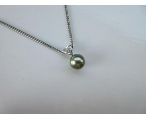 A 'pistachio' yellow-green Tahitian cultured pearl and diamond pendant on chain, the 9mm round pearl with beautiful skin and 