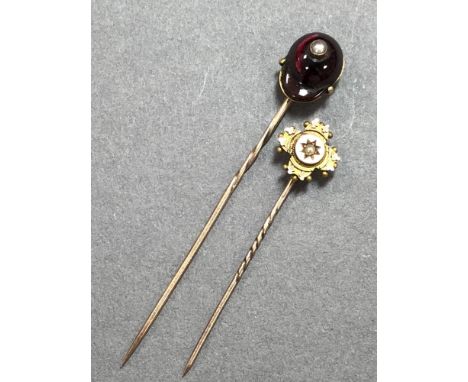 A garnet and seed pearl jockey's cap stick pin and a Victorian gold and seed pearl stick pin, the first with a shaped and cab