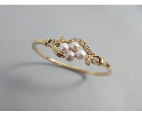 A cultured pearl and white hardstone hinged bangle, set to the front with a cluster of four variously white and blush coloure