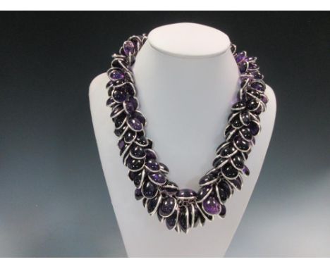 A contemporary amethyst and silver statement necklace, designed as a round link chain with every link suspending two spectacl