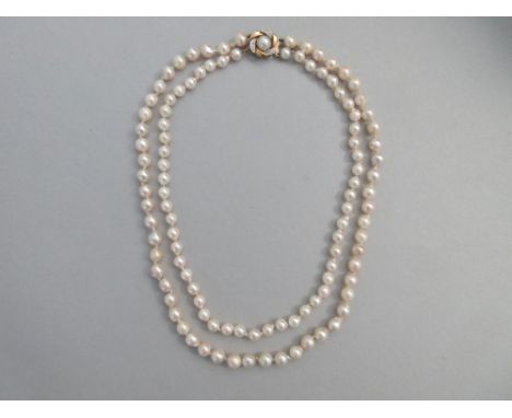 A two row cultured pearl necklace with pearl and diamond clasp, the pearls all individually knotted, the longer string of uni
