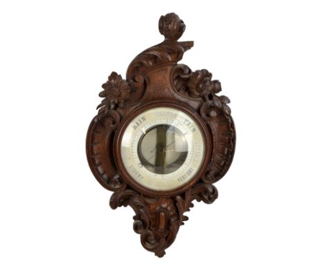 A late 19th century French carved oak barometer with ornate frame and circular dial inscribed 'Metallic Barometer, Bourdon & 