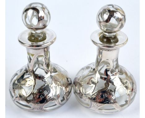 A pair of mid-20th century silver overlaid clear glass floral decorated scent bottles with stoppers, initialled AB, height 7.