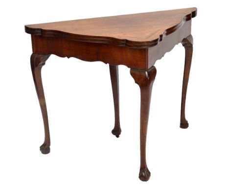 *****AMENDED FROM RED WALNUT*****A George III mahogany shaped triangular foldover card table in the Dutch style, the green ba