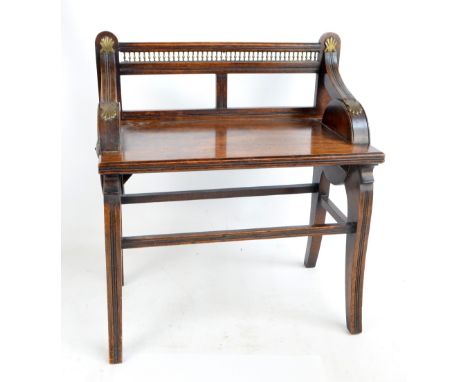 ATTRIBUTED TO JAMES SHOOLBRED & CO; a late Victorian brass mounted oak stool, the rectangular seat with pierced brass galleri