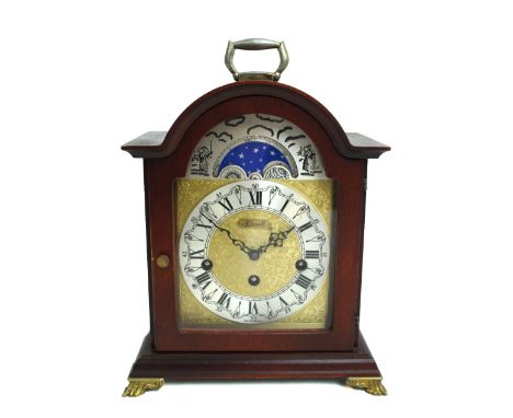 A Hermle oak cased key wind striking and chiming bracket clock, the domed top above silvered moon phase and chapter ring set 