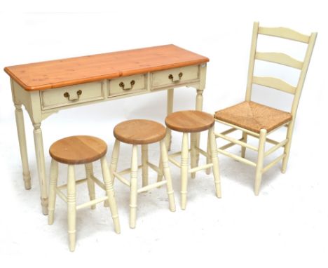 A cream painted console table with pine top above three short drawers, height 80cm, three similarly painted stools and a ladd