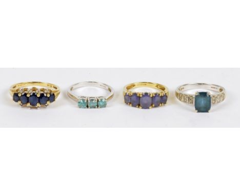 Four 9ct gold costume rings including a yellow gold sapphire five stone set example, size R, and two white gold examples set 