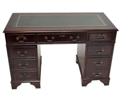A reproduction mahogany pedestal desk with green leather inset top and central drawer flanked by two formations of four drawe