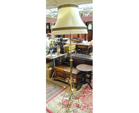A late 19th/early 20th century telescopic brass standard lamp with scroll decoration.