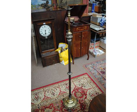 A late 19th century brass standard lamp with fluted central column and three paw feet.