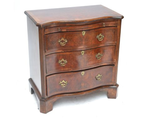 A late 19th century burr walnut and crossbanded serpentine chest of drawers, the shaped top above brushing slide and three lo