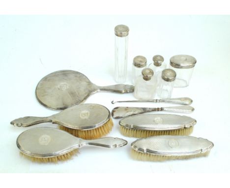 SYNYER & BEDDOES; a George V hallmarked silver mounted engine turned decorated seven piece dressing table set comprising a ci