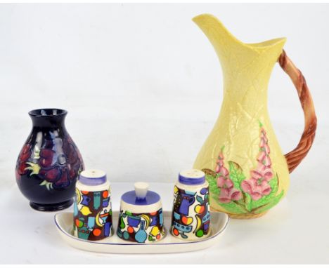 MOORCROFT; an ovoid dark blue ground vase, impressed marks, height 14cm, a Wade three piece cruet and stand decorated with an