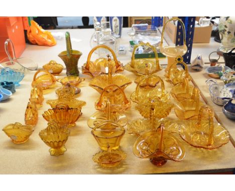 A collection of 19th and 20th century amber tinted glass baskets including two navette form examples by Davidson, an iridesce