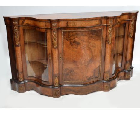 A Victorian inlaid walnut credenza of serpentine outline and with ormolu mounts, central hinged door enclosing single shelf f