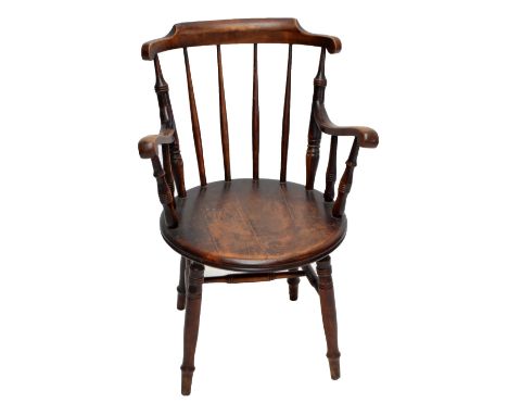 A comb back elbow chair with circular seat and ring turned front legs.