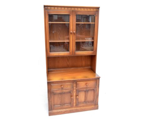 An Ercol side cabinet with twin glazed doors above open aperture and base of two drawers and two cupboard doors, width 98cm.