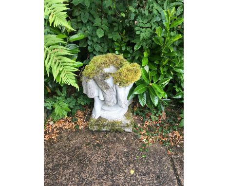 A reconstituted planter, formerly the lower section of a figure showing two feet and raised on a square base, height 60cm.