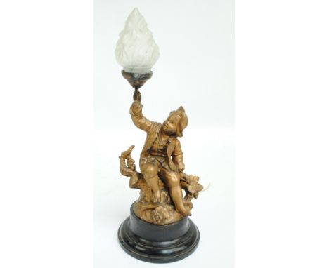 An early 20th century gilt table lamp naturalistically modelled as a young boy upon a bough holding a torch aloft, the froste