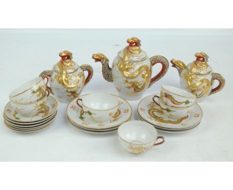 A 20th century Japanese porcelain tea set profusely decorated in gilt and enamels with dragon motif comprising lidded teapot,