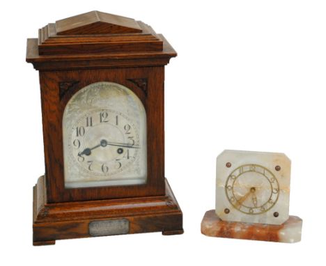 An early 20th century oak cased mantel clock with architectural pediment, the silvered chapter ring set with Arabic numerals 