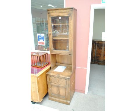 An Ercol side cabinet with glazed upper section and base of single drawer above cupboard door, width 52cm.