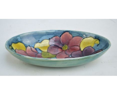 MOORCROFT; a 'Clematis' pattern tube line decorated oval bowl on light blue ground, impressed marks and sticker 'By Appointme