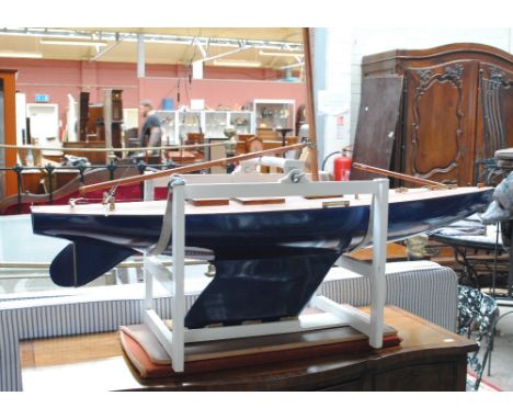 A wooden blue painted model of a yacht with copper mounted masts (sails missing), length 128cm, on display stand.