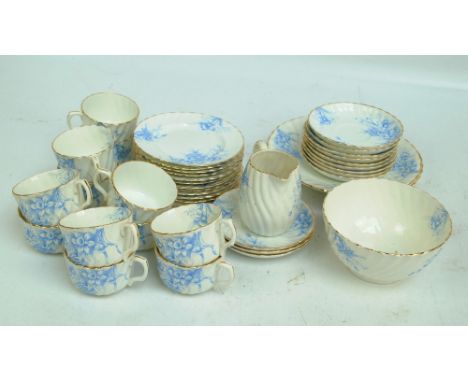 An early 20th century English porcelain tea service decorated with blue daffodils on a cream ground with wrythen moulded deco