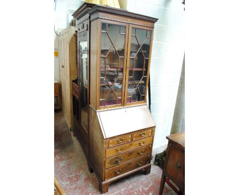 An Edwardian mahogany and inlaid bureau bookcase of small proportions, the moulded dentil cornice above two glazed doors with