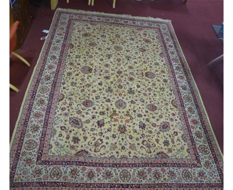 A Persian Tabriz carpet, with all-over hunting, palmette and vine design on a fawn ground, with repeating palmette border and