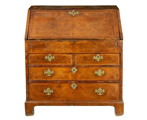 A WILLIAM AND MARY FIGURED WALNUT BUREAU with angled fall revealing a fitted stepped interior with a well above two short and